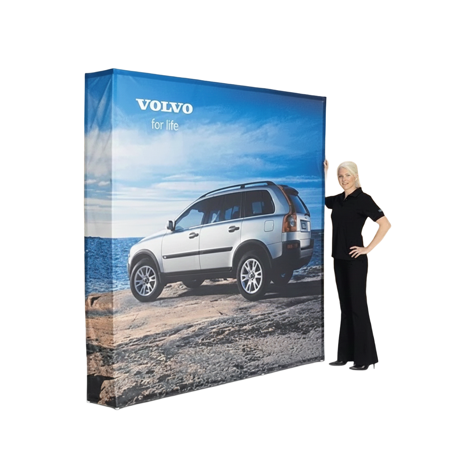 Woman standing next to a large Volvo advertisement featuring a white SUV on a beach.