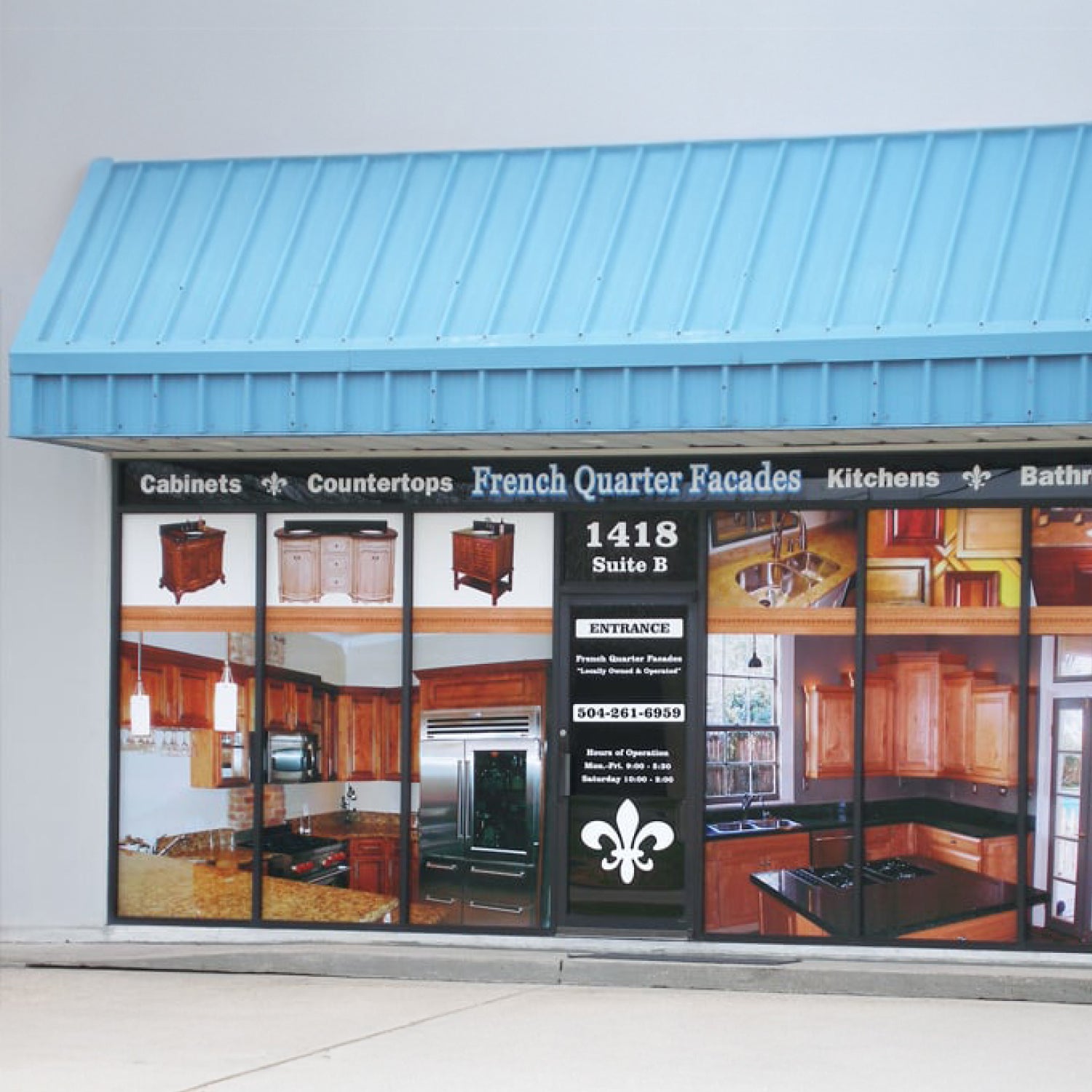 Storefront with a blue awning and promotional display of kitchen and bathroom products.