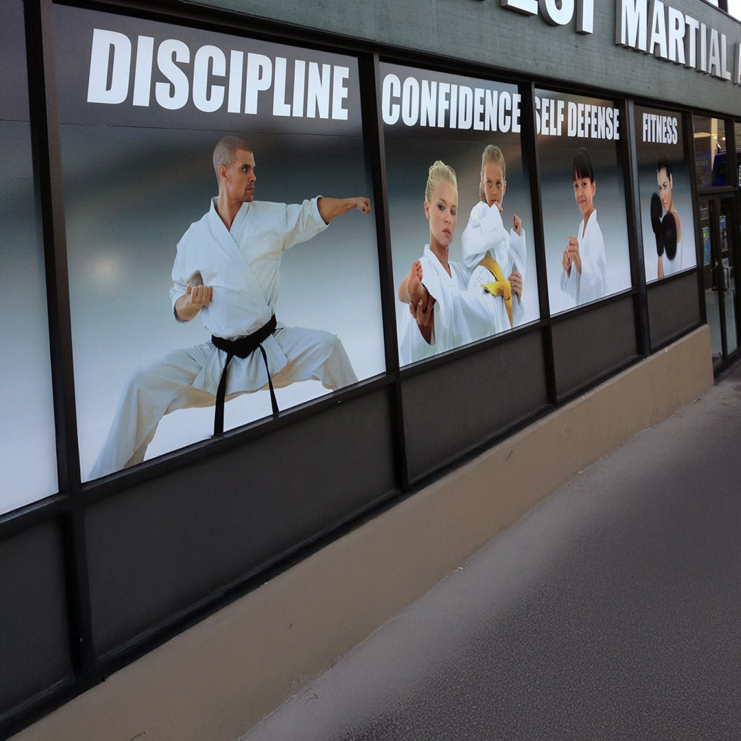 Martial arts studio exterior with promotional posters on a building facade.