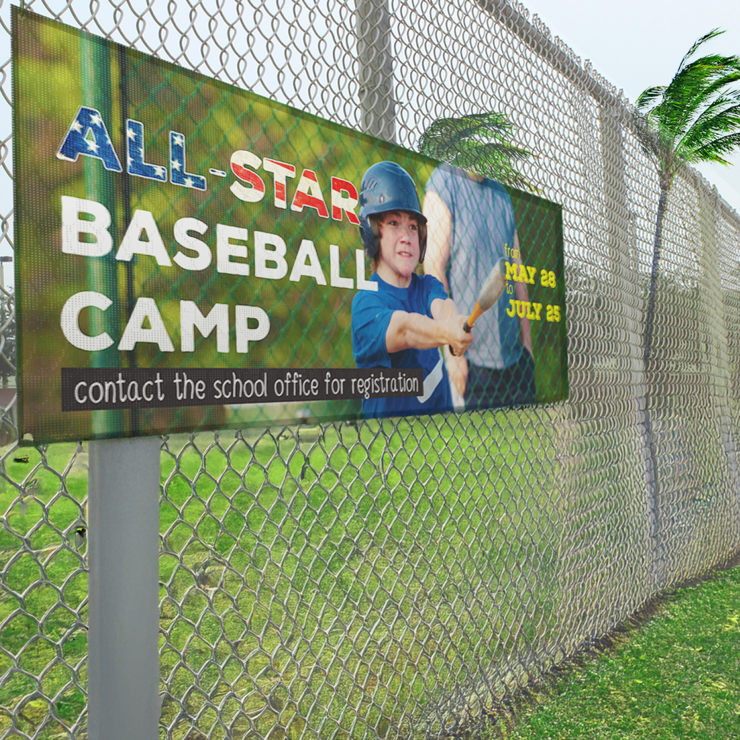 Baseball camp sign on a chain-link fence with a child holding a bat.