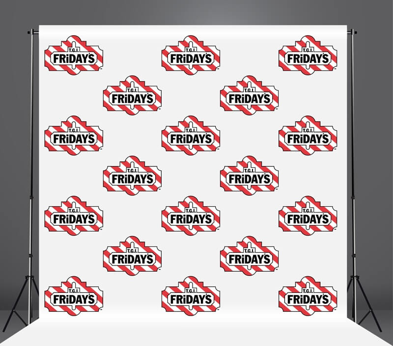 Step and repeat banner with 'Taco Bell Fridays' logos on a stand against a gray background